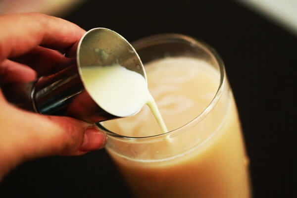 Trút sữa bột nguyên kem, sữa đặc có đường cùng với sữa không đường vào khuấy đều tay.