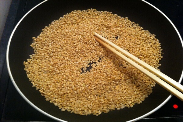 Đổ gạo vào chảo rồi rang cho tới khi gạo bắt đầu có mùi thơm