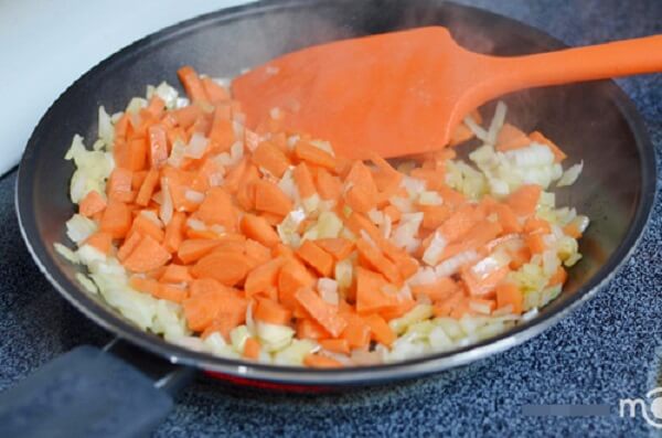Đun nóng dầu ăn rồi cho hành tây, cà rốt vào xào cho đến khi mềm và có màu vàng nâu