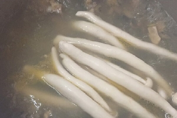 Nấm linh chi trắng thả vào nồi nước dùng. 