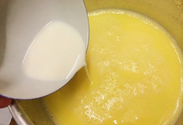 Đổ nước lọc ngô và sữa tươi vào nồi đun sôi lên – cách làm sữa bắp